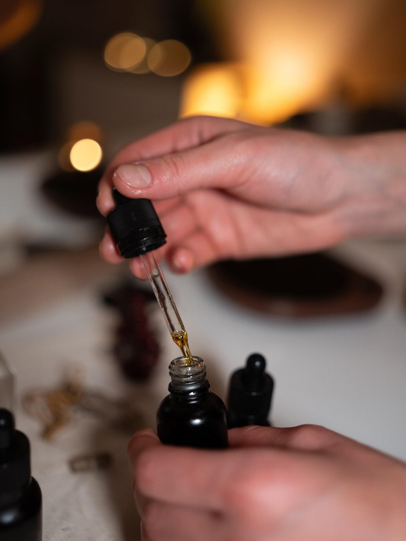 Een pipet druppelt olie terug in een donker flesje